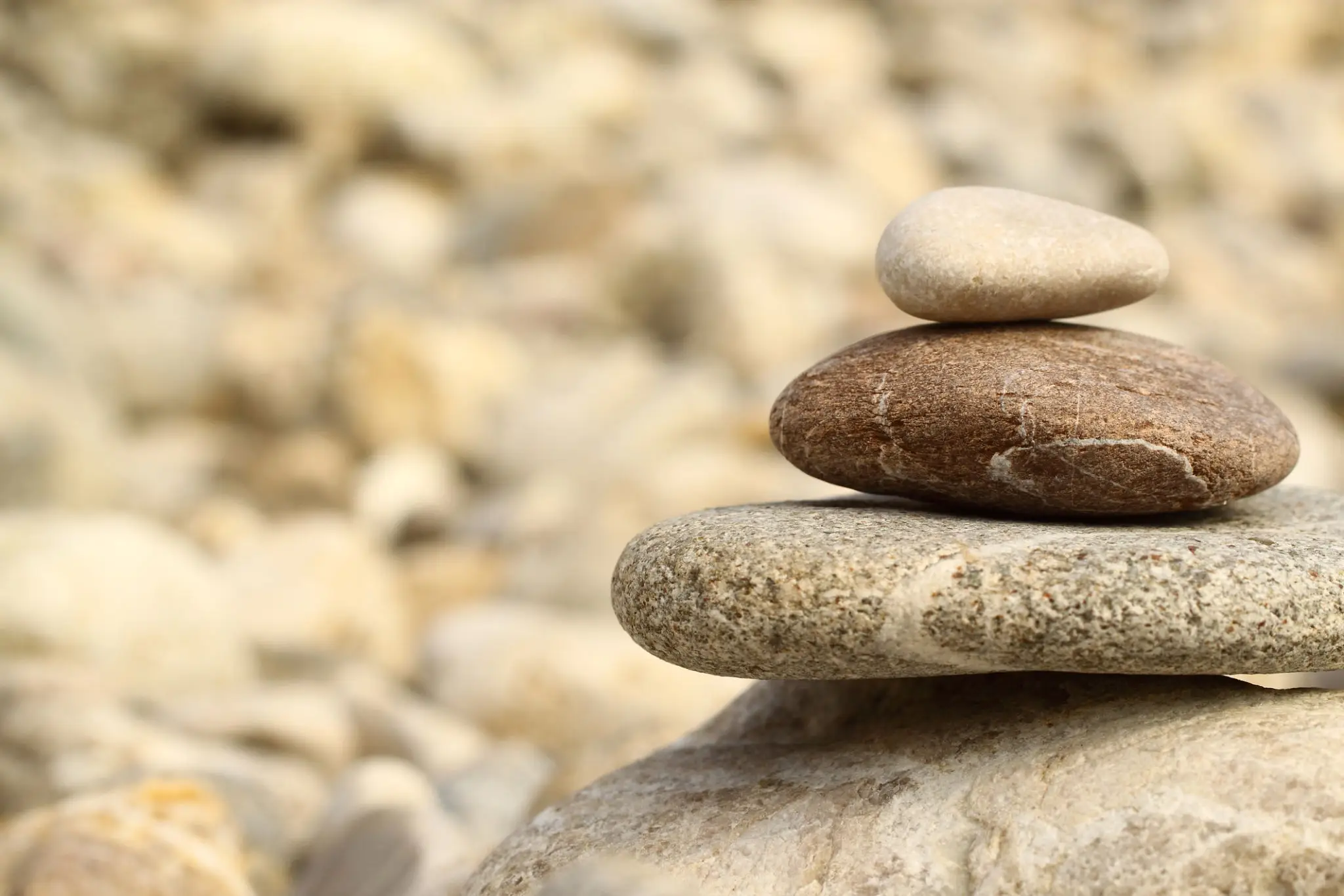 Stack of smooth stones balanced atop each other in a natural setting.