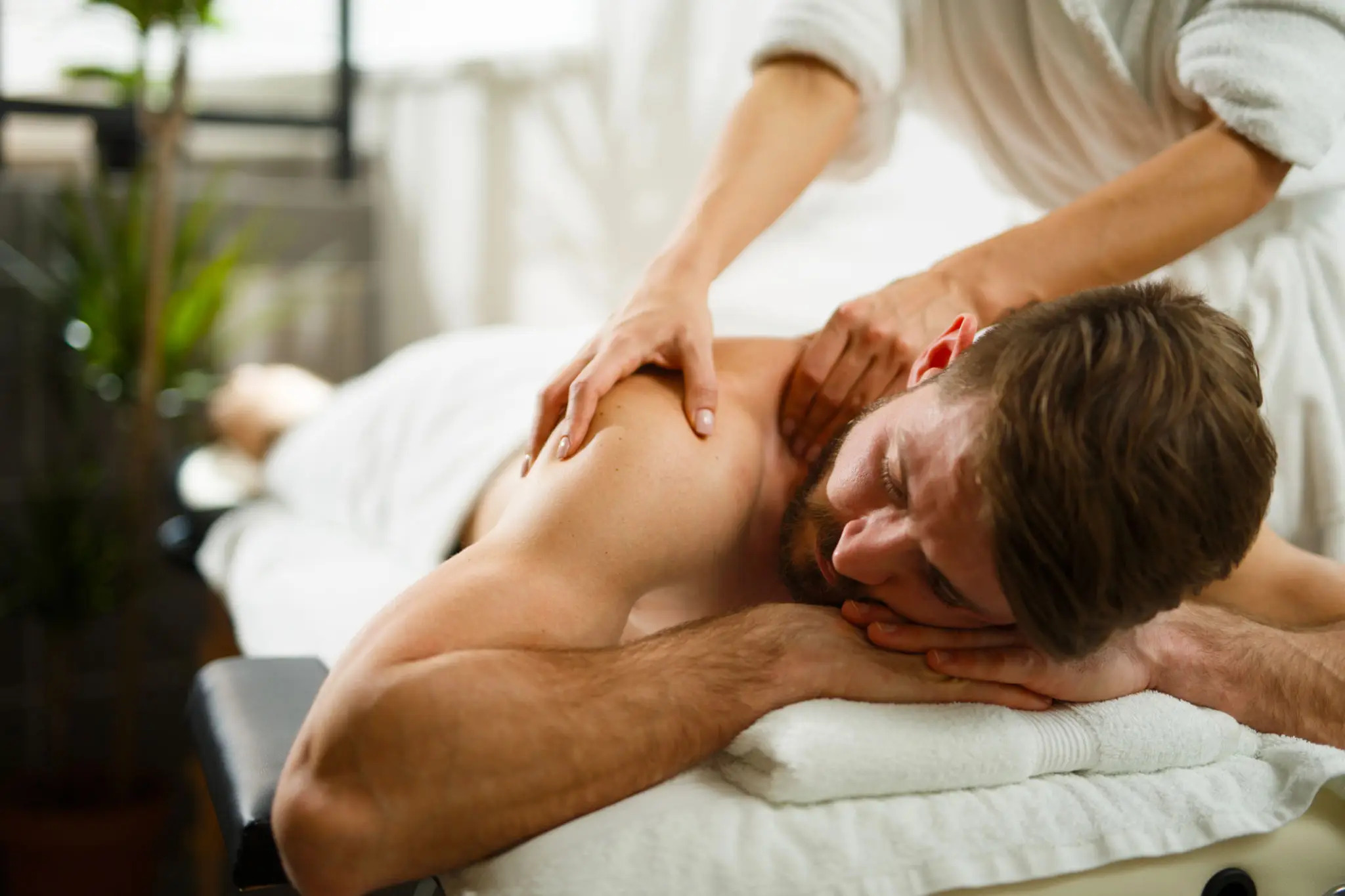 Man receiving a relaxing shoulder massage at a spa.